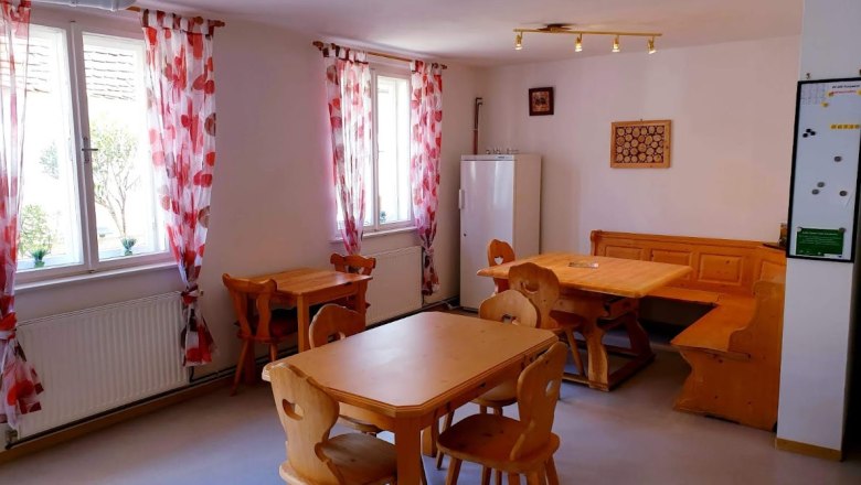Krell Winery, © Weingut Krell Cozy room with wooden furniture and red curtains.