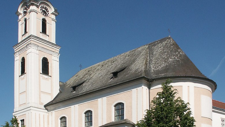 Minorite Church Tulln, © Donau Niederösterreich The Minoritenkirche church in Tulln with its striking tower and baroque architecture against a blue sky.