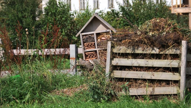nuetzlingshotel_kompost_klein_c_kraeuterdorf_merkenbrechts, © Kräuterdorf Merkenbrechts An insect hotel next to a compost heap in a garden with green grass and trees in the background.