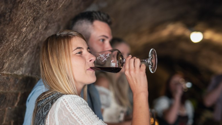 Winery Küssler, © Winzerhof Küssler Woman drinking wine in a wine cellar.