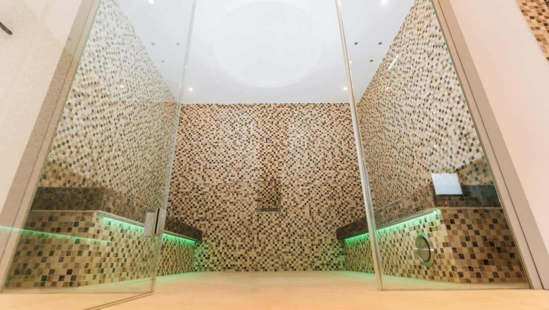 New sauna area, © Sporthotel Semmering Modern sauna area with mosaic tiles and glass walls.