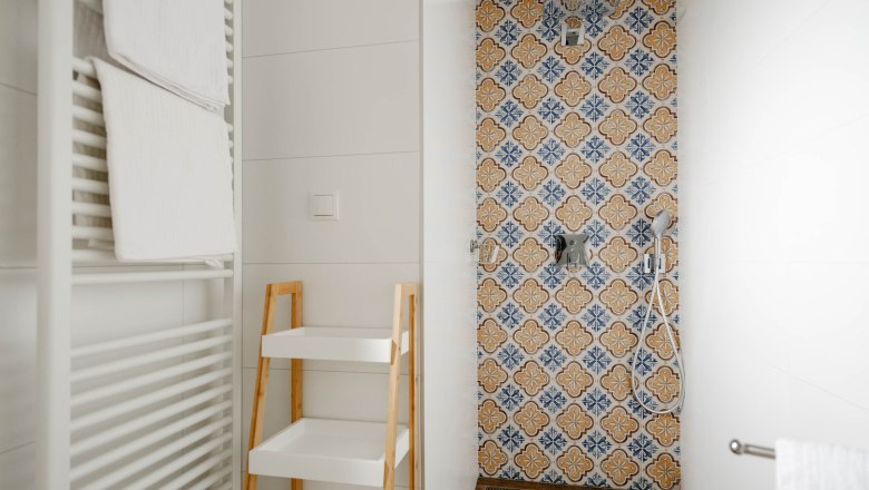 Bathroom Gelber Muskateller, © Michael Reidinger Modern bathroom with patterned tiles in the shower, towel rail and shelf.