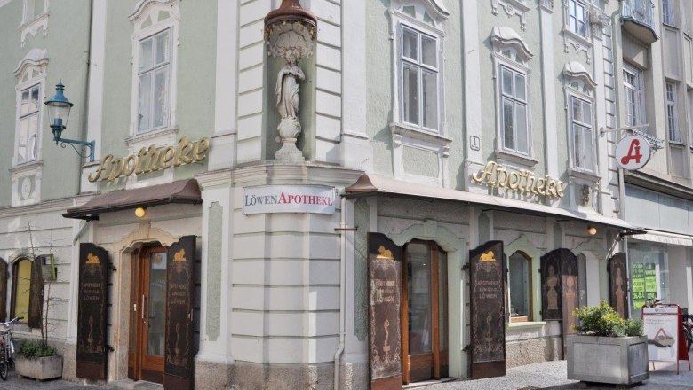 Lion Pharmacy, © Werner Jäger Historic pharmacy with a green façade and golden lettering in a town.