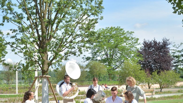 Tulln's Nibelungenplatz, © Stadtgemeinde Tulln MEnschen group sitting chatting in the background band playing music