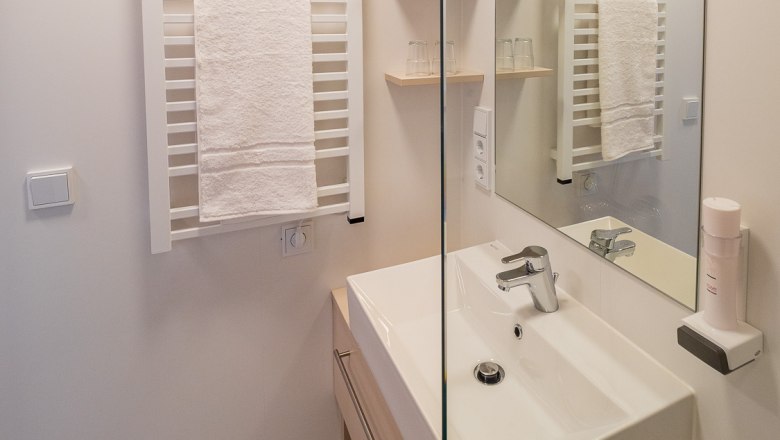 Bathroom, © freilich / IsaBella Fritsche Modern bathroom with washbasin, mirror and towel rail.
