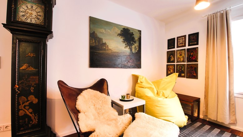 Living area Top 2 Sitting area, © Daniela Sinadinoska Cozy seating area with leather armchair, yellow beanbag, antique grandfather clock and murals.