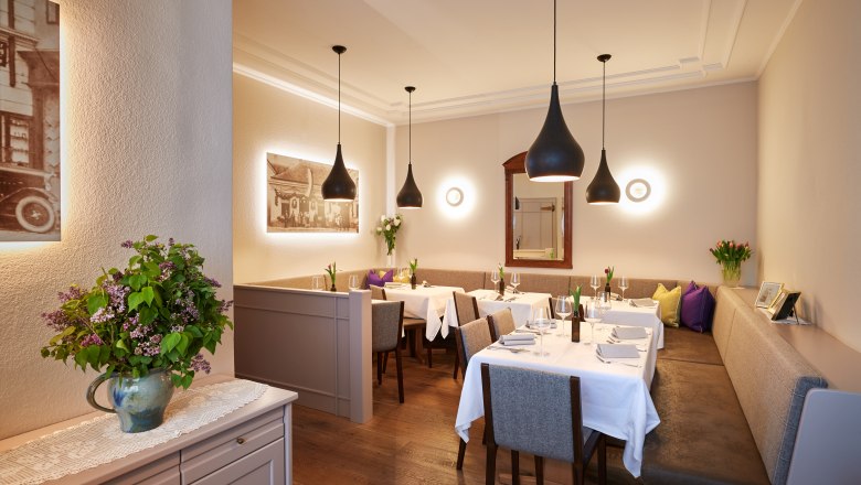 Modern guest room, © Niederösterreich Werbung/Andreas Hofer Elegant restaurant with laid tables, modern lamps and flower arrangements.