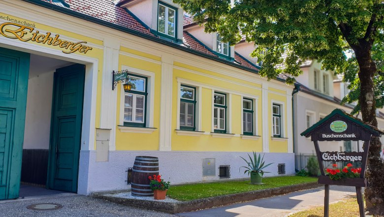 Buschenschank (typical tavern), © Weingut Eichberger Yellow building with green doors and windows, sign 'Buschenschank Eichberger', tree in the foreground.