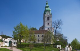 Parish church Unterretzbach, © Gemeinde Retzbach Church in Unterretzbach with green tower and surrounding buildings.