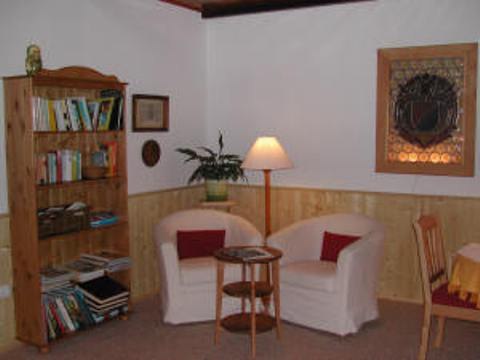 Sitting area, © Pension Lindenhof Cozy sitting area with two armchairs, a small table, bookshelf and floor lamp.