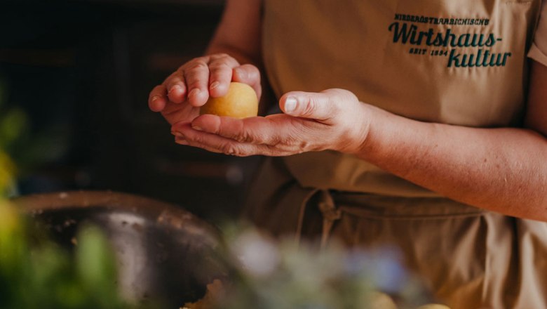 Typical Waldviertel cuisine, © Niederösterreich Werbung/Daniela Führer Person forms a yellow ball of dough in their hand.