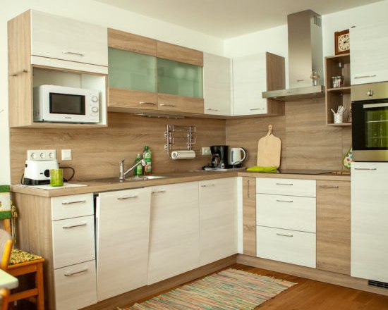 Kitchen, © Michael Sokolar Modern kitchen with wooden and white cupboards, microwave, coffee machine and oven.