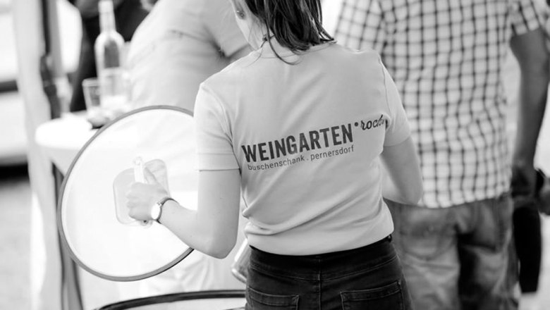 Weingarten.rocks - Buschenschank (typical tavern), © Weingarten.rocks Woman in a T-shirt with the inscription 'Weingarten.rocks' at an event.