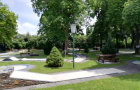 Mini golf Wiener Neustadt, © Minigolf Wiener Neustadt Minigolf course with trees and benches in a park.