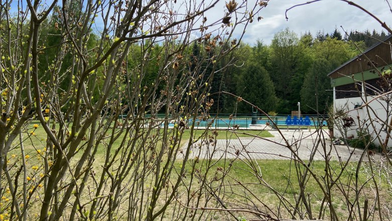 Sonnenwaldbad Pulkau, © Weinstraße Weinviertel An outdoor pool with empty pools, surrounded by trees and bushes.