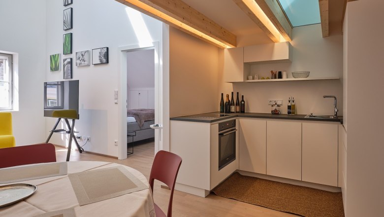 Equipment details in House Five, © Prof. Arch. DI Dietmar Kraus Modern kitchen with wooden beams, dining table and view into the bedroom.