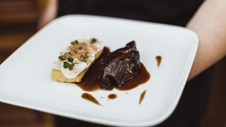 Beef cheeks, mushroom on potato soufflé, © Niederösterreich Werbung/David Schreiber A plate of beef cheeks in sauce and mushrooms on potato soufflé.