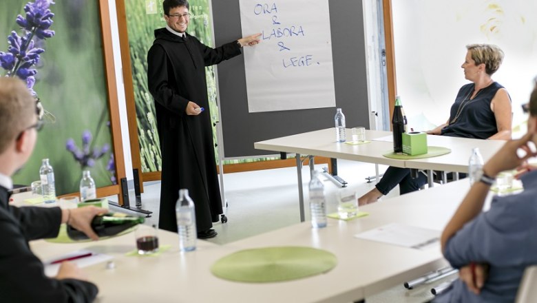 Seminars at Seitenstetten Abbey, © Dori Schwarz König A seminar at Seitenstetten Abbey with a lecturer dressed as a monk pointing at a flipchart. Participants sit at tables.