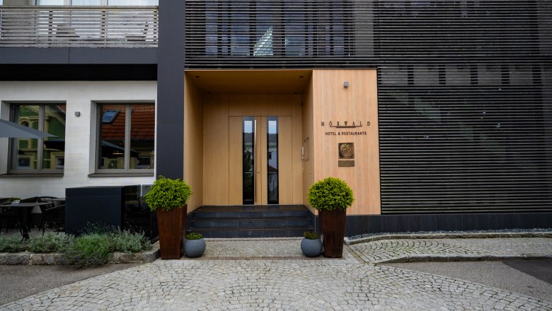 Relais & Chateaux Mörwald Hotel am Wagram, © Niederösterreich Werbung / Maximilian Pawlikowsky Entrance to the Relais & Chateaux Mörwald Hotel with modern architecture and paved forecourt.