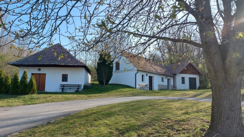 Altruppersdorf wine cellar lane, © Vino Versum Poysdorf White buildings with red roofs in a rural setting, trees in the foreground.