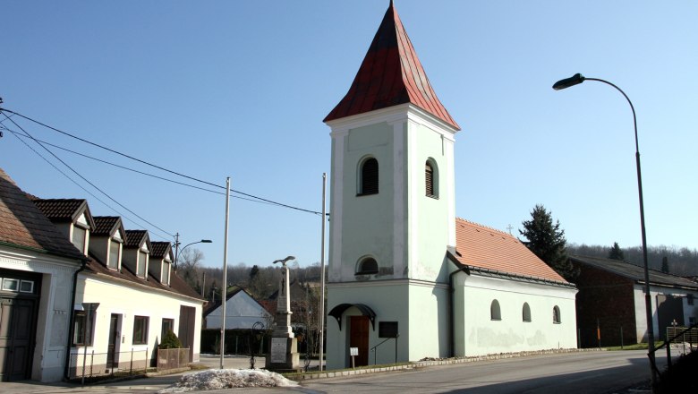 Guttenbrunn, © Gemeinde Ottenthal Church with red roof and tower in a village under a clear sky.