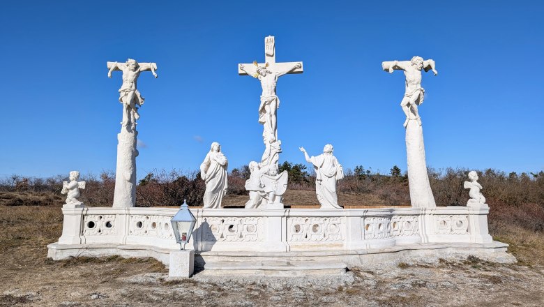 Calvary, © Retzer Land / Daniel Wöhrer Calvary with three crosses and statues against a blue sky.