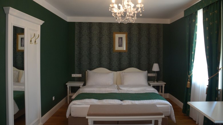 Empress Zita Room, © Engelbrecht Elegant hotel room with green decor, double bed, chandelier and curtains.