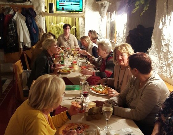 Pizzeria Borsalino, © Pizzeria Borsalino Group of people eating in a cozy pizzeria.