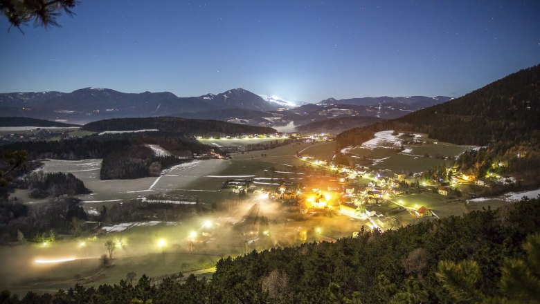 Municipality of Prigglitz, © Franz Zwickl Nocturnal landscape view of Prigglitz with illuminated houses and mountains in the background.