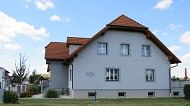 Exterior view of the Ehrenleitner family guest room, © Fam. Ehrenleitner Exterior view of a gray house with a red roof and several windows.