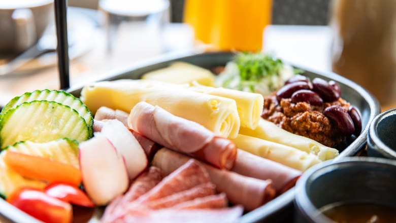 Breakfast, © Alexander Künzl Photography Close-up of a breakfast plate with cheese, ham, salami, vegetables and beans.
