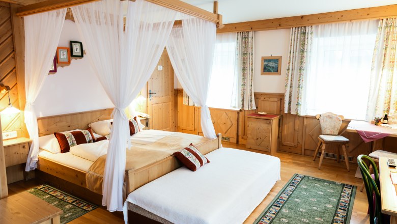 Double room Cat. B, © Scharfegger´s Raxalpen Resort Cozy hotel room with four-poster bed, wooden furniture and carpets.