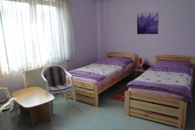 Pension Steindl, © Familie Steindl A simply furnished room with two single beds, a small table and two chairs.