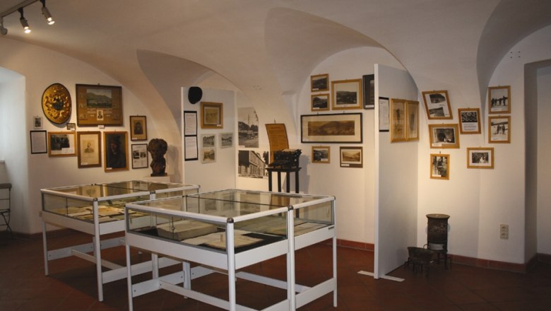 Purkersdorf City Museum, © Stadtmuseum Purkersdorf Interior view of a museum room with display cases and historical photos on the walls.