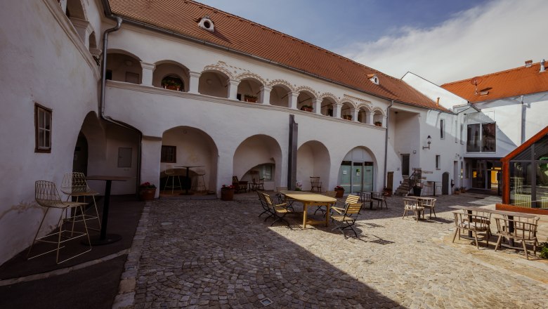 forty yard, © Niederösterreich Werbung / Maximilian Pawlikowsky Inner courtyard of a historic building with arcades and seating.