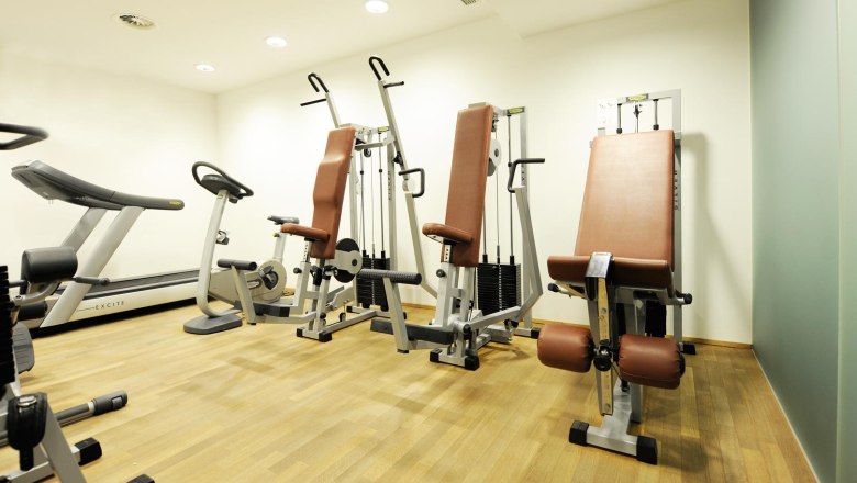 Fitness room, © Boutiquehotel hein A fitness room with treadmill, exercise bike and strength equipment on a wooden floor.