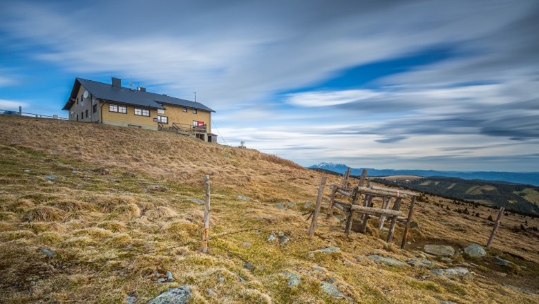 Wetterkoglerhaus on the Hochwechsel, © Wiener Alpen, Christian Kremsl Mountain hut on a hill with a cloudy sky in the background.