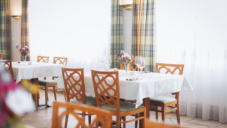 Perfect for parties and celebrations, © Niederösterreich Werbung/David Schreiber Elegant restaurant with laid tables, flower arrangements and wine glasses.