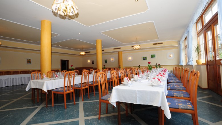 Hall - suitable for a wide range of celebrations, © Fam. Auer GMBH A festively decorated hall with long tables and wooden chairs, suitable for celebrations.