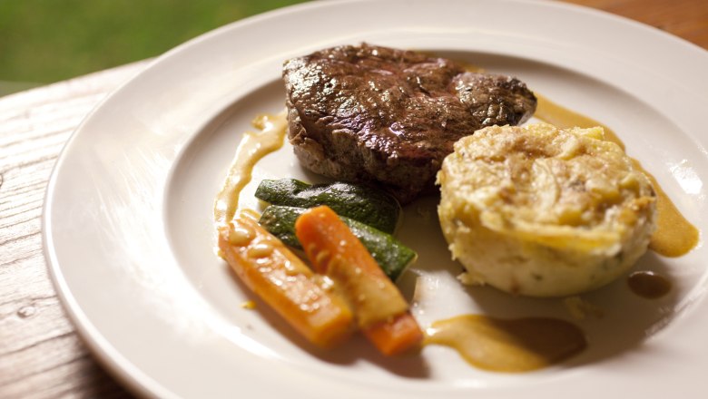Enjoyment in the Weinviertel, © Weinviertel Tourismus / Wurnig A plate of steak, vegetables and potato gratin.