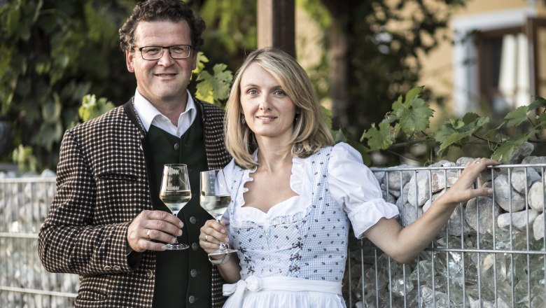 Sonja and Markus Oßberger, © Nino Zimmerhackl A man and a woman in traditional dress are holding wine glasses.