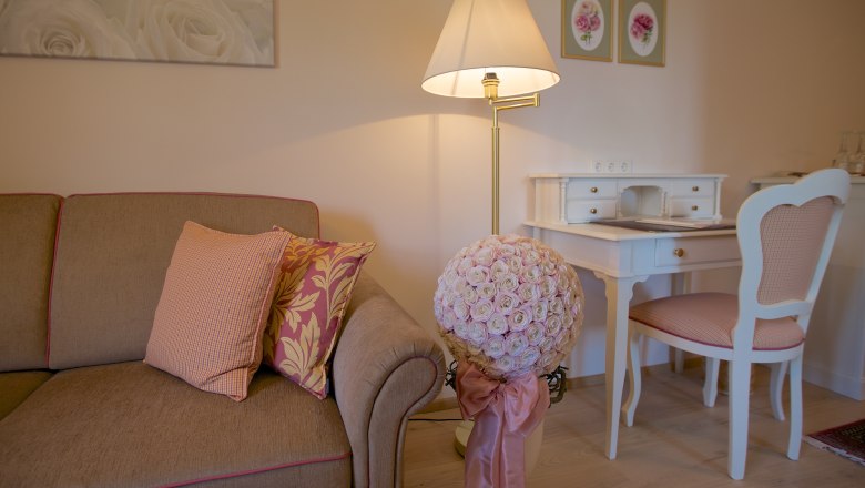 Rose romance, © www.wachaufoto.at Cozy living room with sofa, desk and flower arrangement.