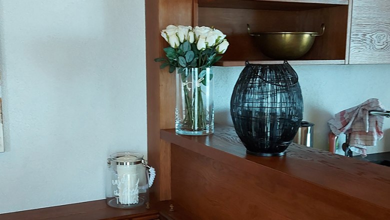 Kitchen, © Bernadette Gierlinger Wooden kitchen with shelves, cushions and decorations.