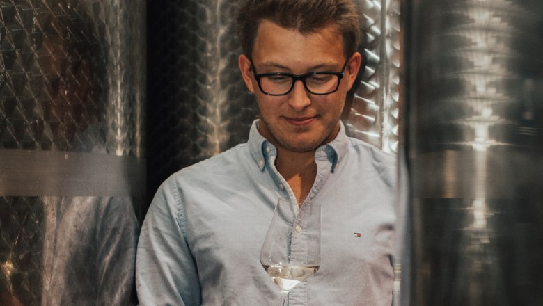 Paul Zimmermann, © Winzerhof Zimmermann Man with glasses holding a wine glass in a wine cellar.