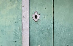 Cellar door, © Weinviertel Tourismus / Wurnig Green wooden door with metal fittings and a keyhole.