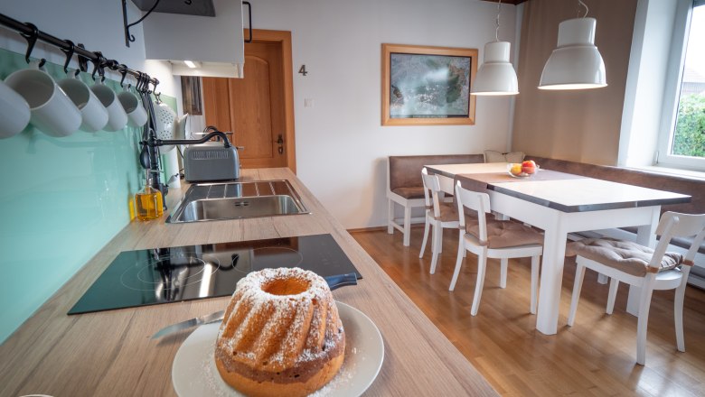 Eat-in kitchen, © Doris Eminger Modern eat-in kitchen with dining table, chairs and Gugelhupf on the worktop.