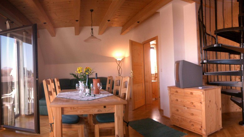 Apartment, © Gartner Clemens Living room with wooden furniture, dining table, spiral staircase and balcony.