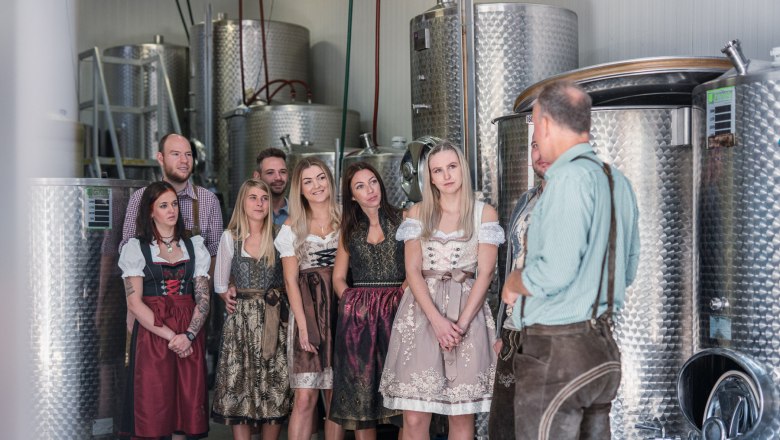 Winery Küssler, © Winzerhof Küssler Group of people in traditional dress in a brewery.