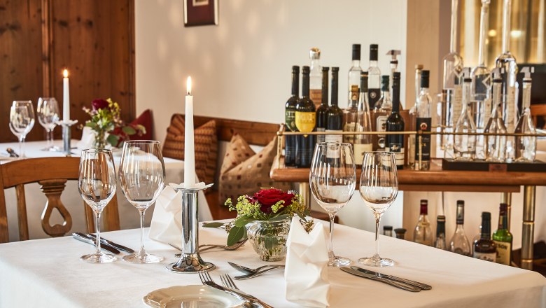 Restaurant Weinstube, © Steigenberger Hotel and Spa, Gregor Titze Elegant table in hotel restaurant with wine glasses, candle and flowers.