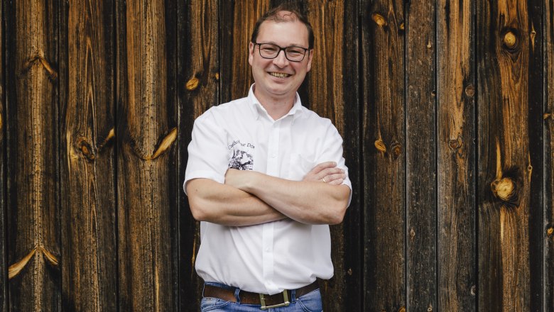 Landlord Reinhard Lang, © Niederösterreich Werbung/David Schreiber Man in white shirt in front of wooden wall.